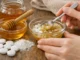 Aspirinas trituradas mezclándose con miel en un bowl de vidrio, preparando una mascarilla facial casera